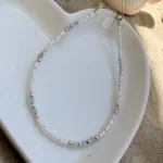 פנינת אורז עדינה 2-3 מ"מ משולבת בחרוזי גולדפילד עם אבני חן בגוון תכלת עדין